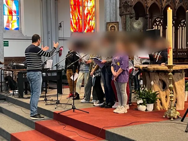 La chorale du collège chante dans une église, accompagnée de musiciens.