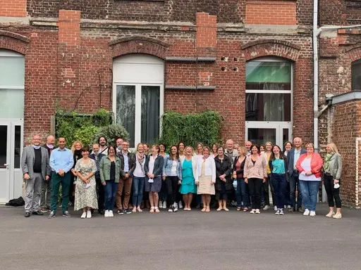 L’équipe du collège réunie devant un bâtiment en briques.