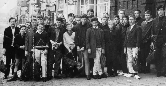 Photo d’archive en noir et blanc : un groupe d’élèves du Sacré-Cœur dans la rue de Lille, à Halluin.