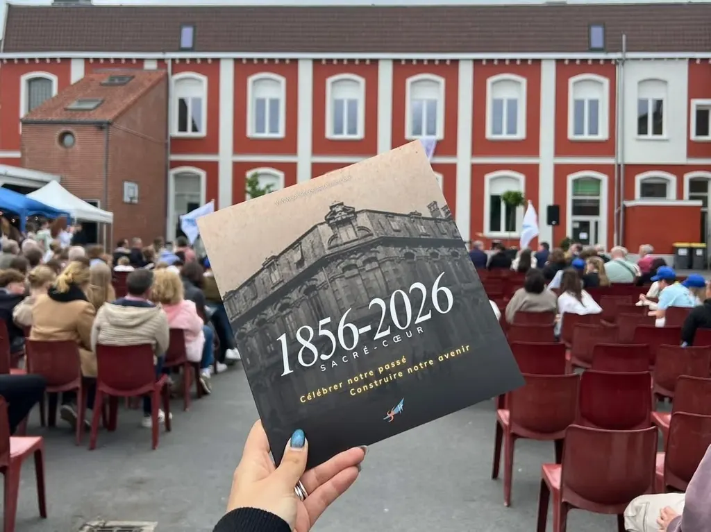 Le livret « 1856-2026, Sacré-Cœur » tenu devant la cour du collège, le jour de la fête des 170 ans.